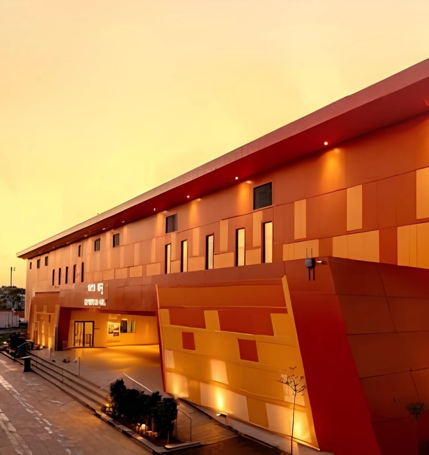 Warm orange exterior of Vayu Hall at ATI ONGC, Goa